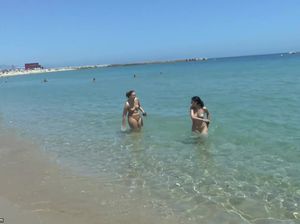 Голые девушки на пляже резвятся в воде