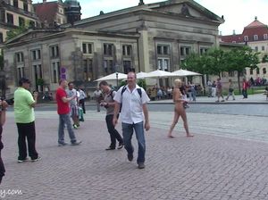 Голая телка позирует туристам посреди площади