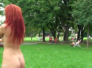 Рыжуха с татуировкой на животе позирует без одежды около памятника