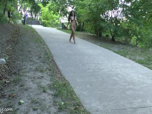 Немка с красивым загаром прогуливается по людному парку без одежды